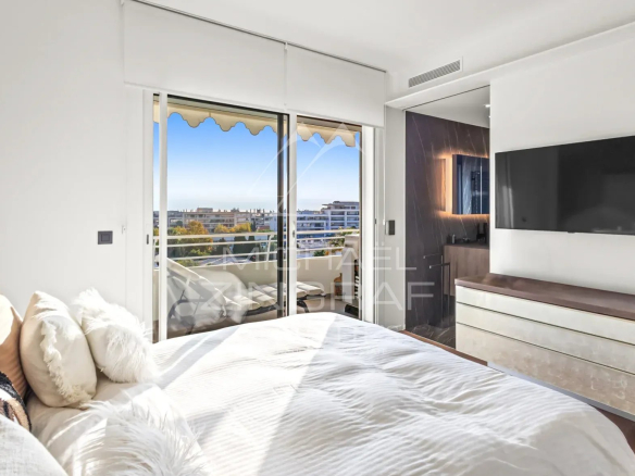 Chambre d'un appartement rénové à Cannes avec vue sur la mer et balcon.