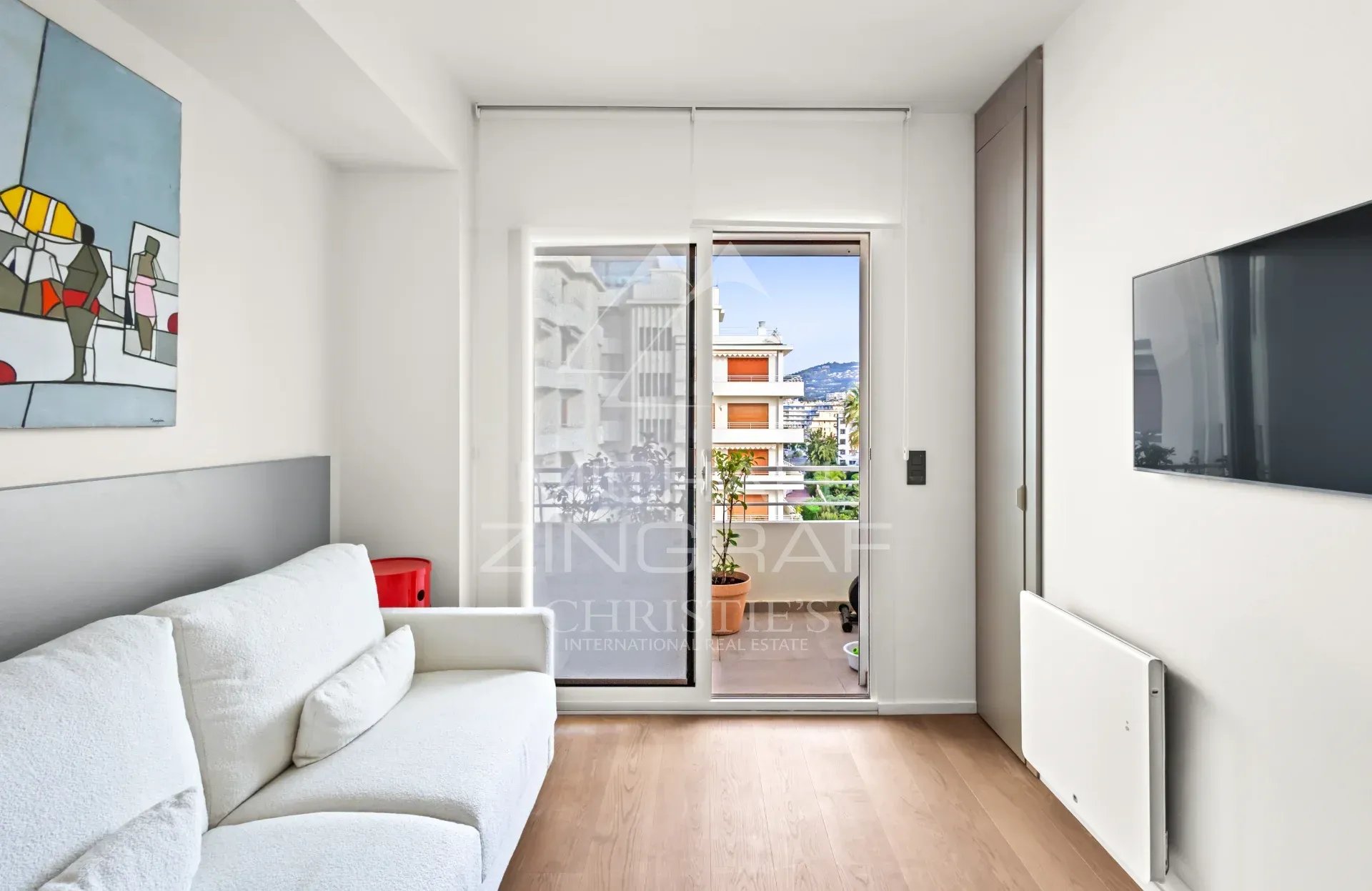 Appartement rénové à Cannes Intérieur d'un appartement rénové à Cannes avec un salon lumineux et accès à une terrasse.