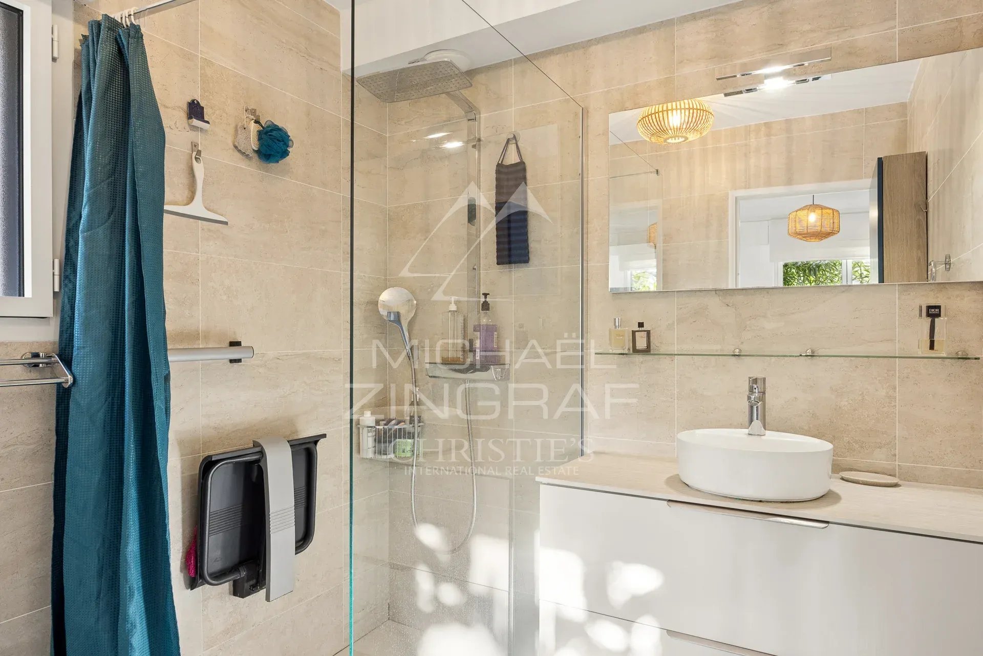 Salle de bain moderne avec douche en verre et lavabo sur meuble.