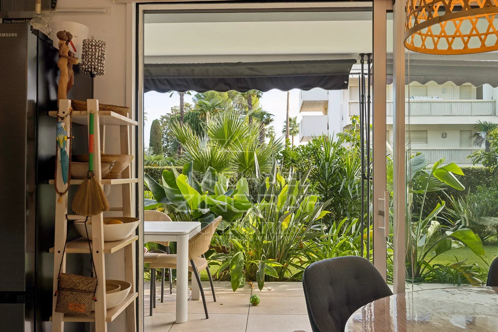Vue depuis l'intérieur d'un appartement sur un jardin verdoyant à Cannes.