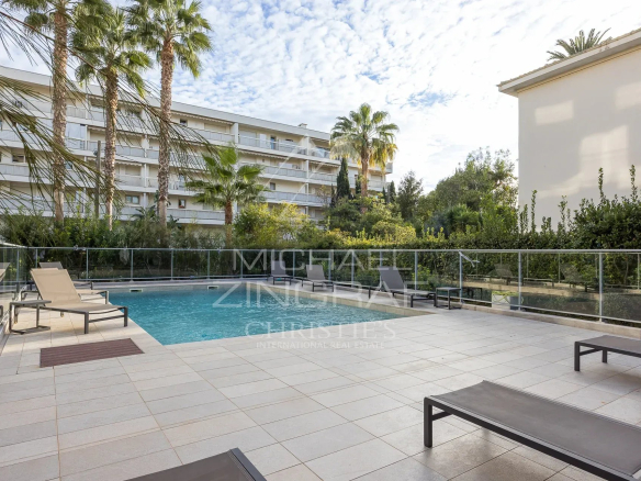 Piscine entourée de chaises longues dans une résidence à Cannes.