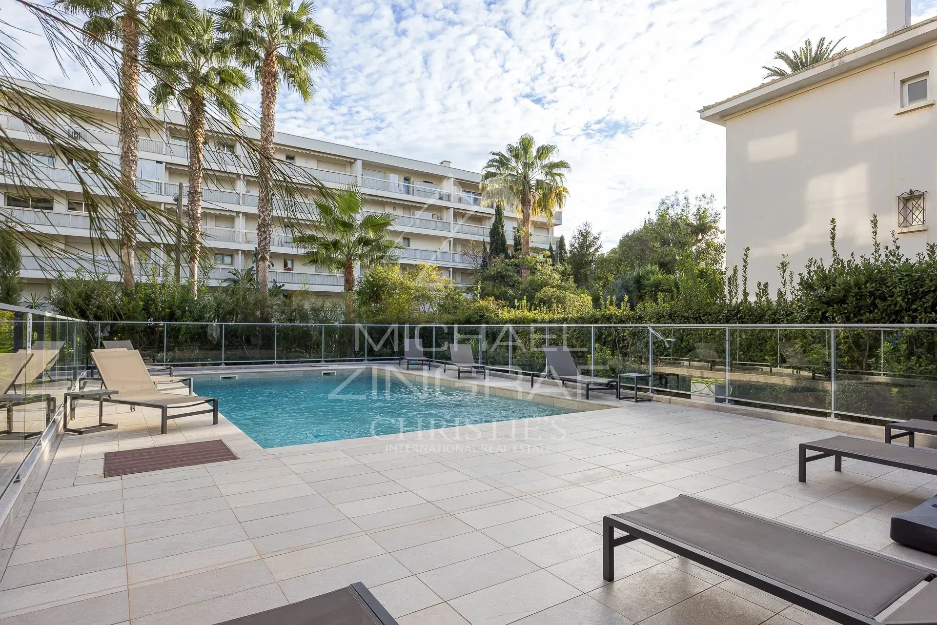 Piscine entourée de chaises longues dans une résidence à Cannes.