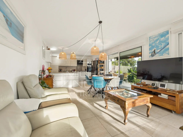 Intérieur d'un appartement 3 pièces avec salon, cuisine ouverte et accès au jardin.