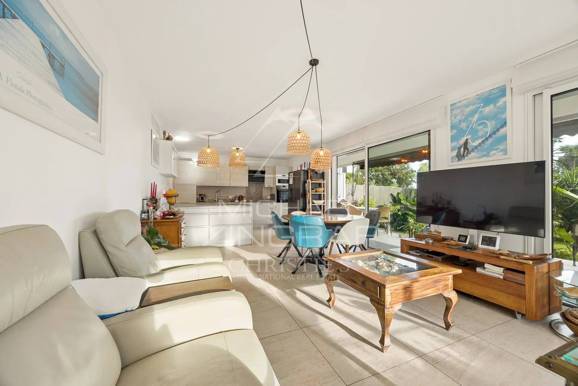 Intérieur d'un appartement 3 pièces avec salon, cuisine ouverte et accès au jardin.