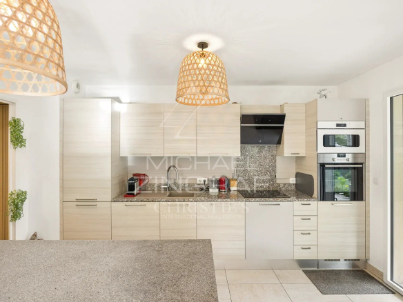 Cuisine moderne d'un appartement à Cannes avec meubles clairs et équipements intégrés.