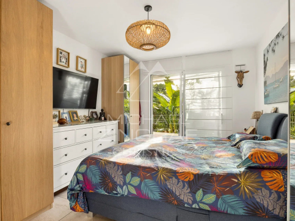 Chambre d'un appartement à Cannes avec lit double et décoration colorée.