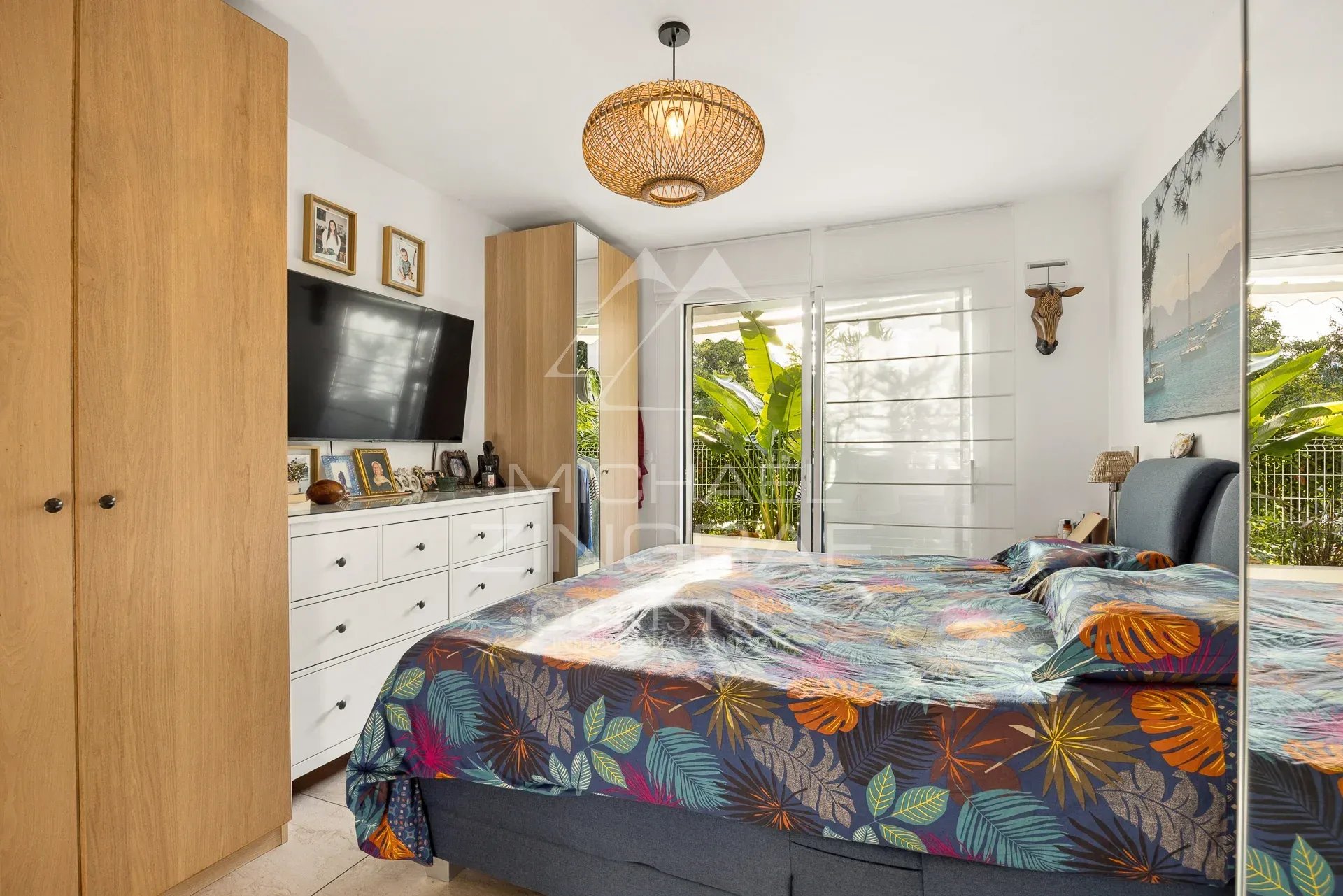 Chambre d'un appartement à Cannes avec lit double et décoration colorée.
