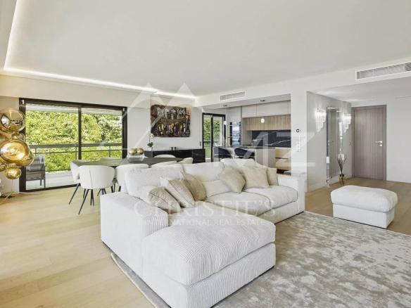Intérieur d'un appartement contemporain à Cannes avec vue sur la mer, salon lumineux et terrasse.