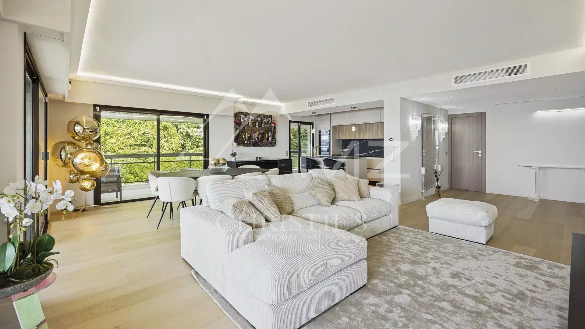 Intérieur d'un appartement contemporain à Cannes avec vue sur la mer, salon lumineux et terrasse.