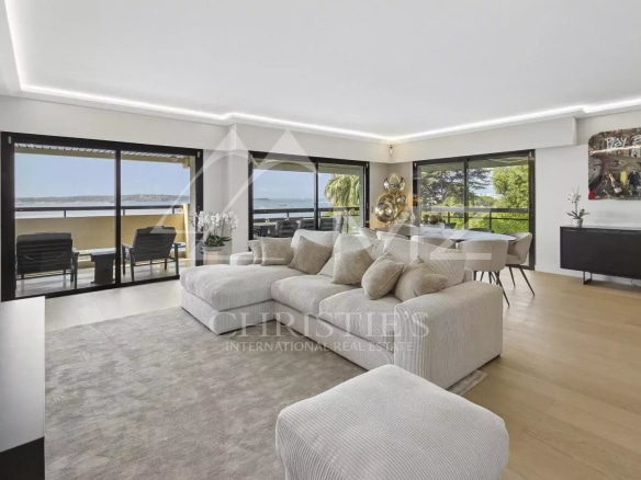 Intérieur d'un appartement contemporain avec vue sur la mer à Cannes, salon lumineux et terrasse.