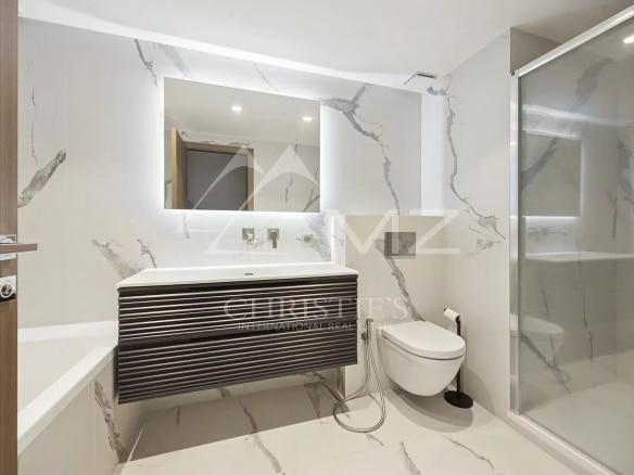 Salle de bain moderne avec douche et baignoire dans un appartement contemporain à Cannes.