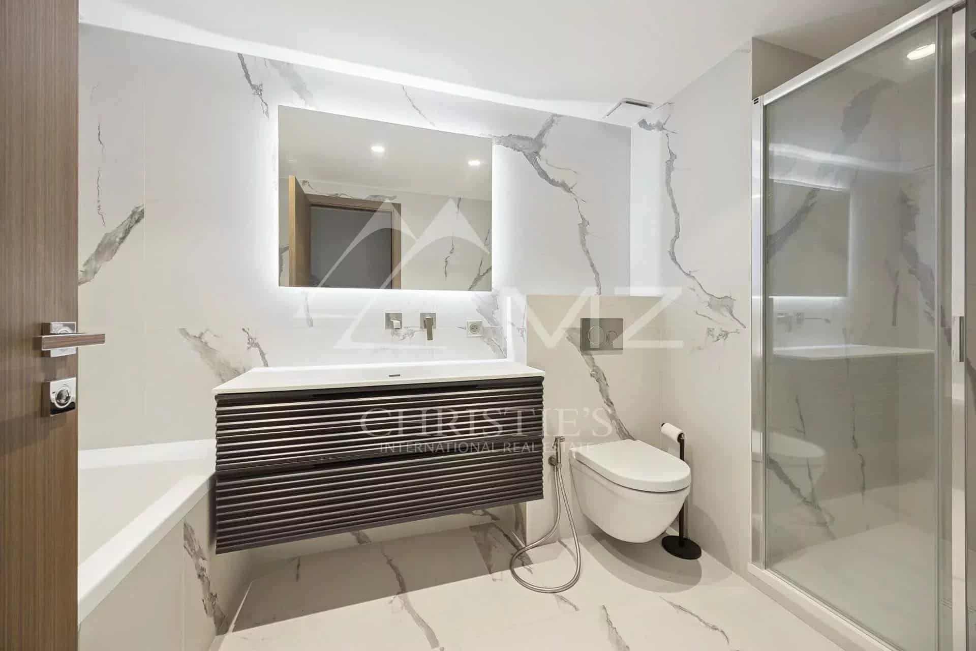 Salle de bain moderne avec douche et baignoire dans un appartement contemporain à Cannes.