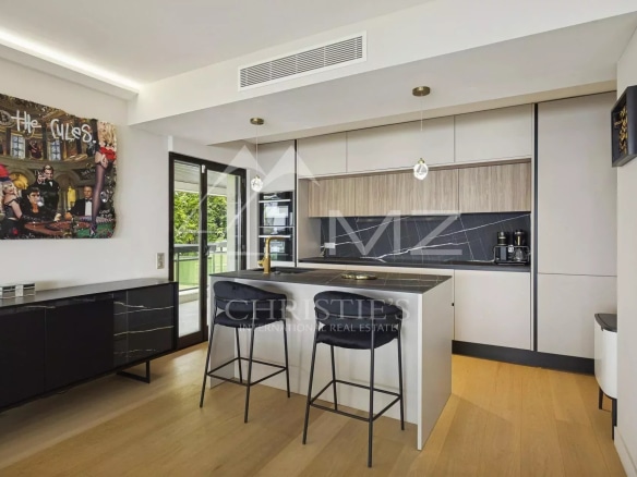 Cuisine moderne d'un appartement contemporain à Cannes avec bar et espace de vie lumineux.