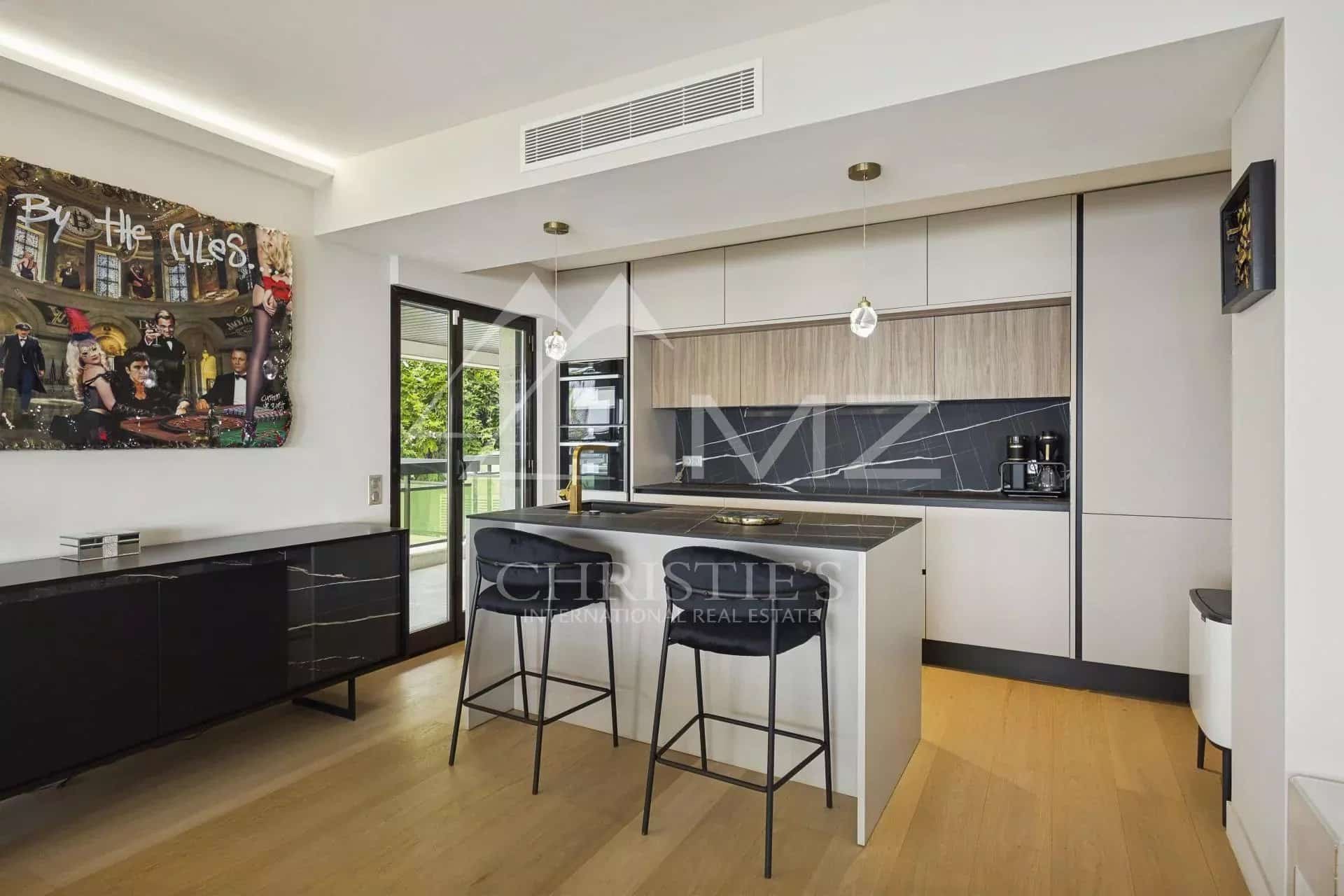 Cuisine moderne d'un appartement contemporain à Cannes avec bar et espace de vie lumineux.
