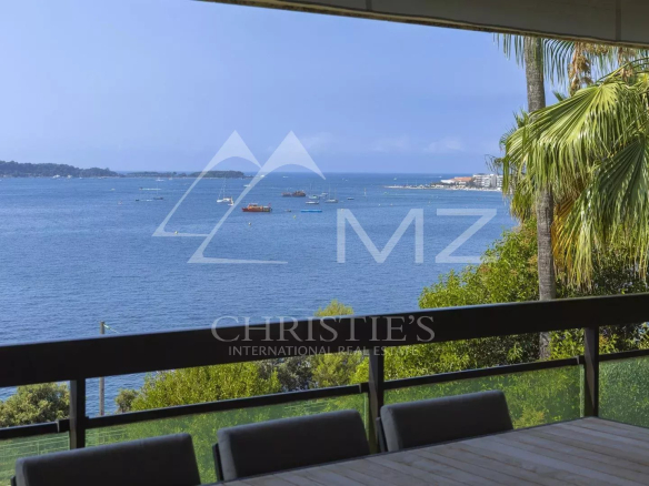 Vue panoramique sur la Méditerranée depuis un appartement à Cannes, avec terrasse et mobilier extérieur.