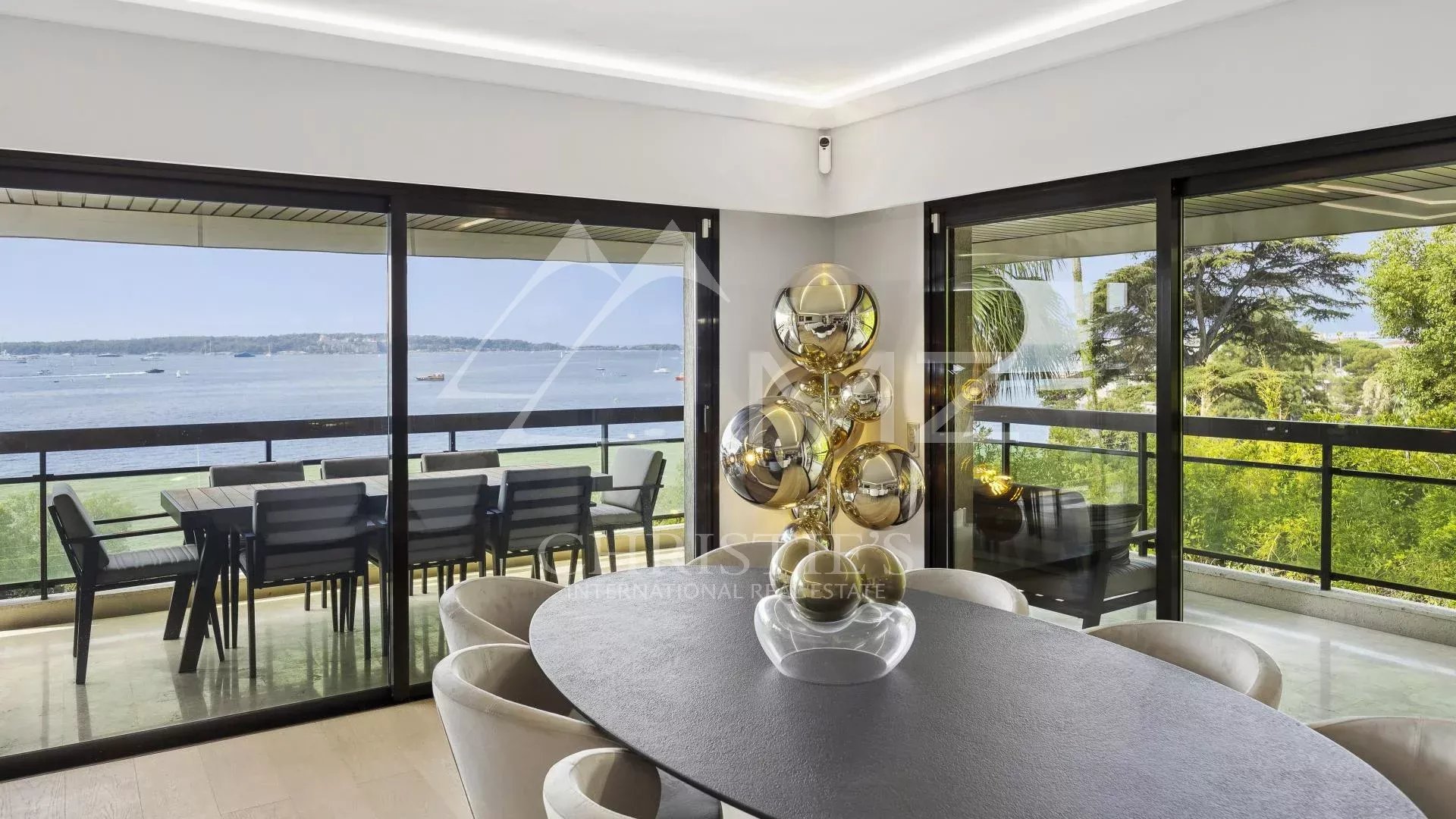 Intérieur d'un appartement contemporain avec vue sur la mer à Cannes, salle à manger et terrasse.