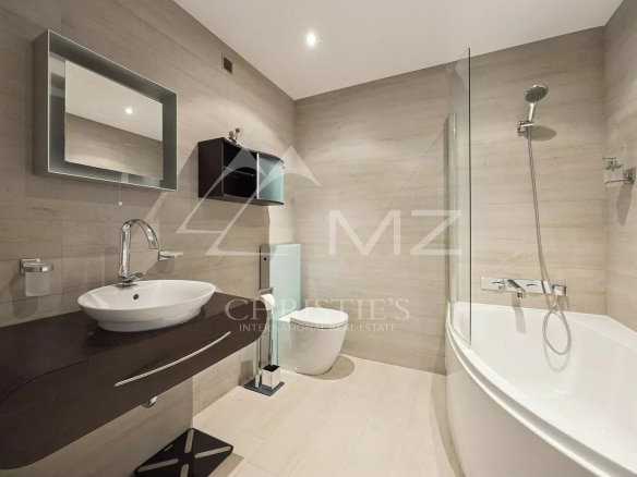 Modern bathroom with bathtub, sink and toilet in a recently built apartment.