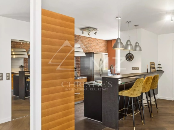 Modern kitchen with bar and high chairs in a bright apartment.