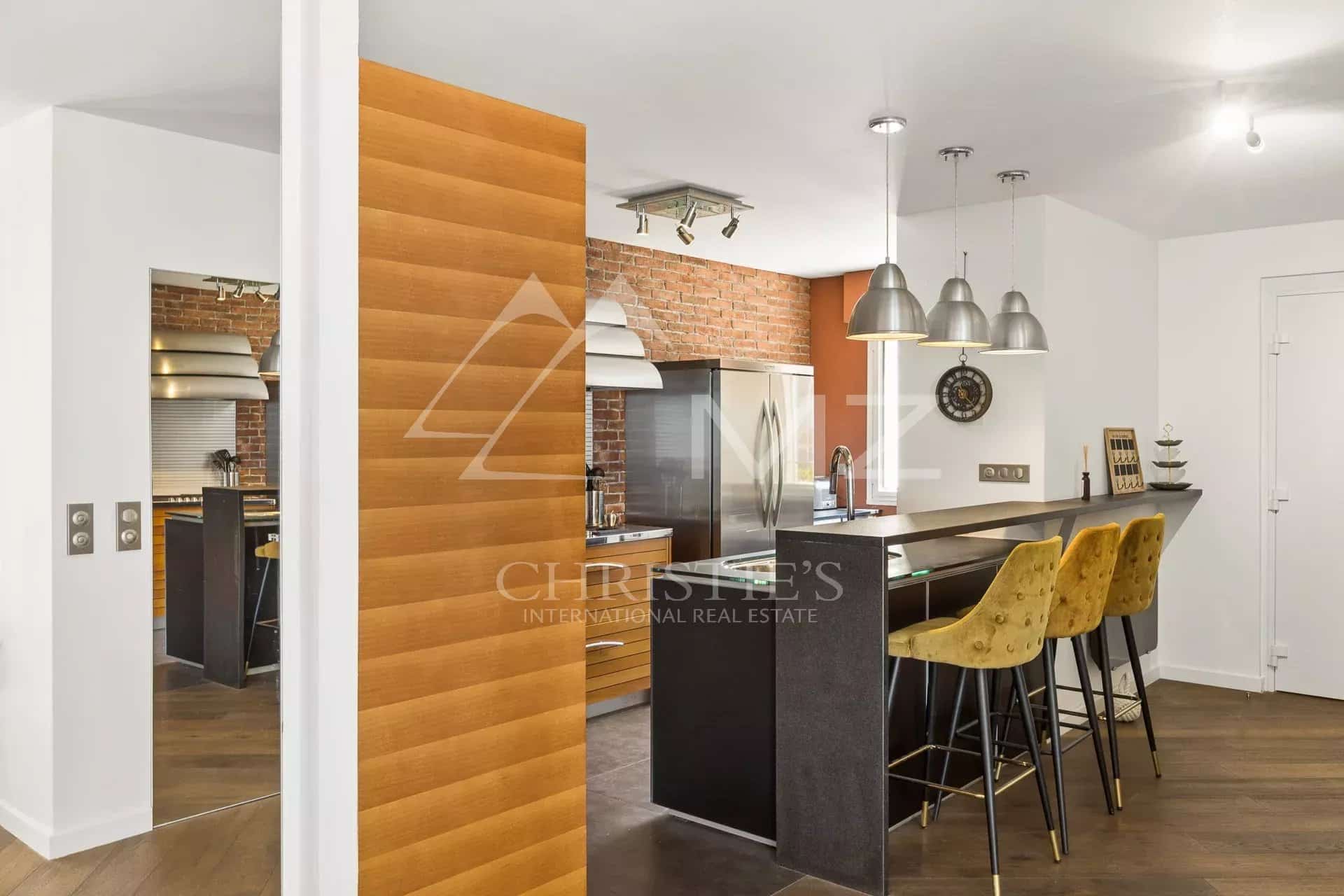 Kitchen in an apartment with a view in Le Cannet Modern kitchen with bar and high chairs in a bright apartment.