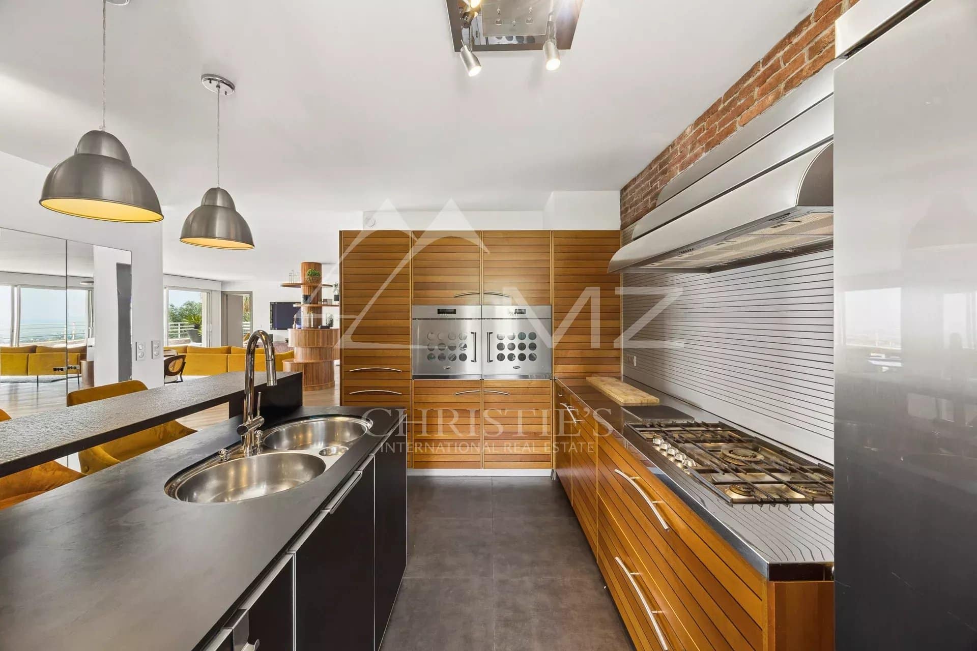 Modern kitchen in an apartment in Le Cannet Modern kitchen with wood and stainless steel elements, open to a bright living space.