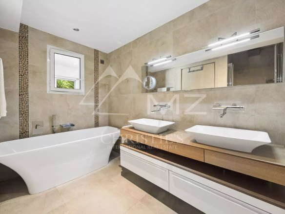 Modern bathroom with bathtub and double sink in an apartment.