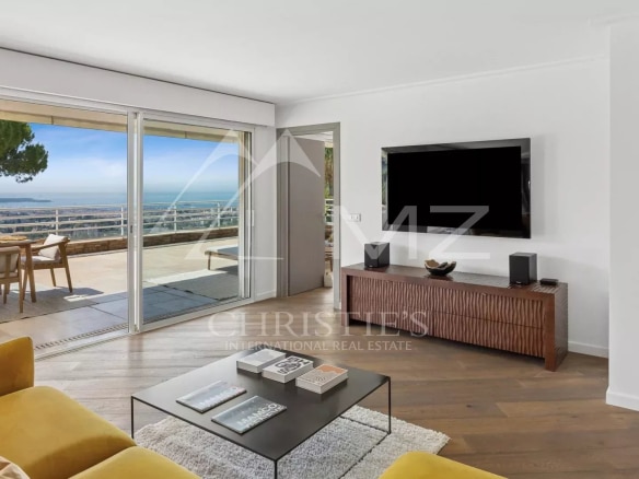 Bright living room of an apartment with sea view, terrace and modern furniture.