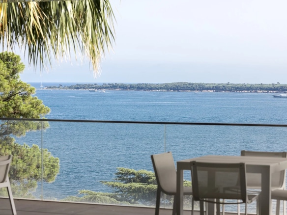 Vue sur la mer depuis une terrasse d'appartement à Cannes, avec mobilier extérieur.