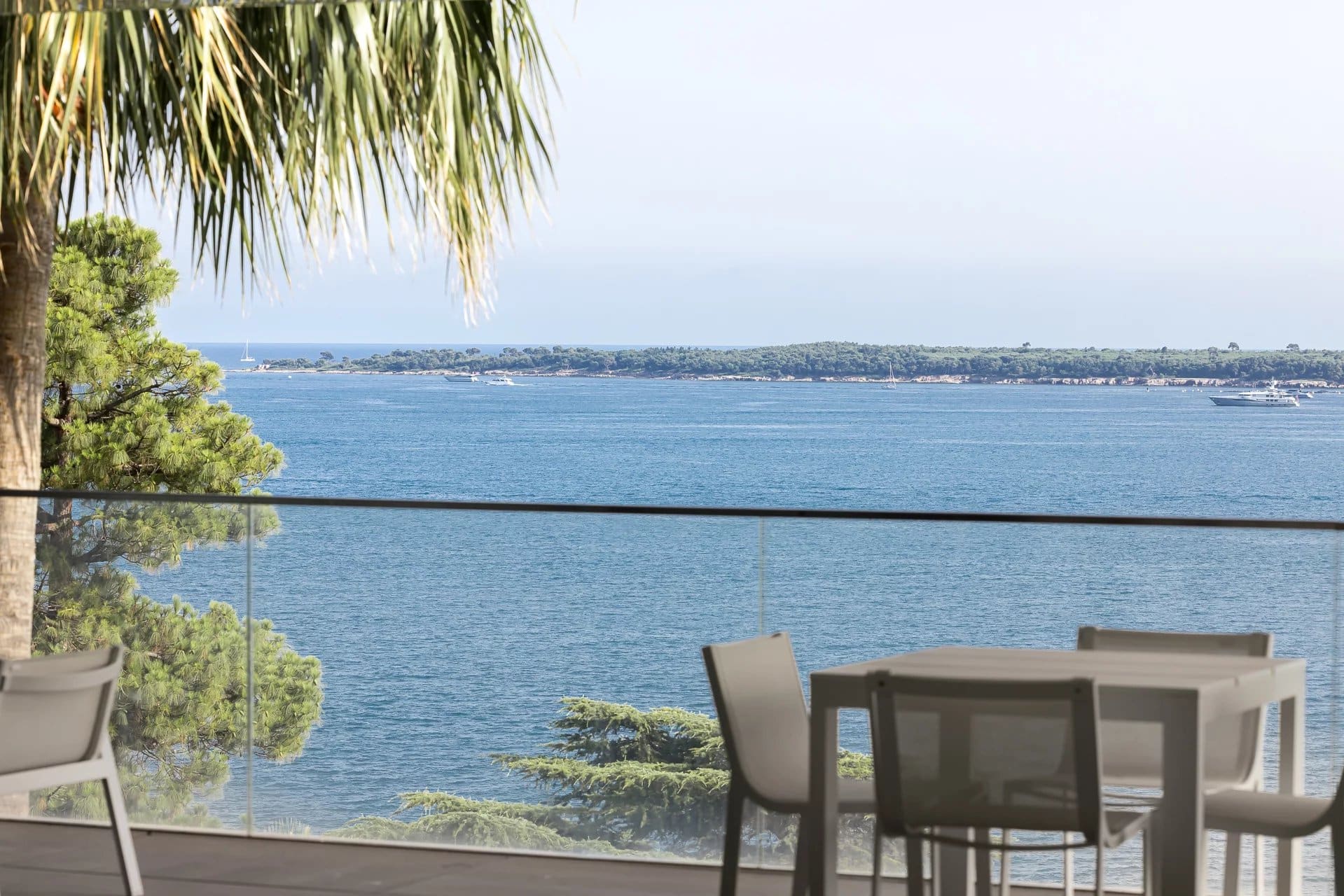 Vue sur la mer depuis une terrasse d'appartement à Cannes, avec mobilier extérieur.
