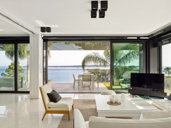 Intérieur d'un appartement moderne avec vue sur la mer à Cannes, terrasse spacieuse et mobilier contemporain.