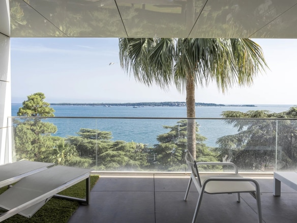 Terrasse d'un appartement de luxe avec vue sur la mer à Cannes, palmier et mobilier moderne.
