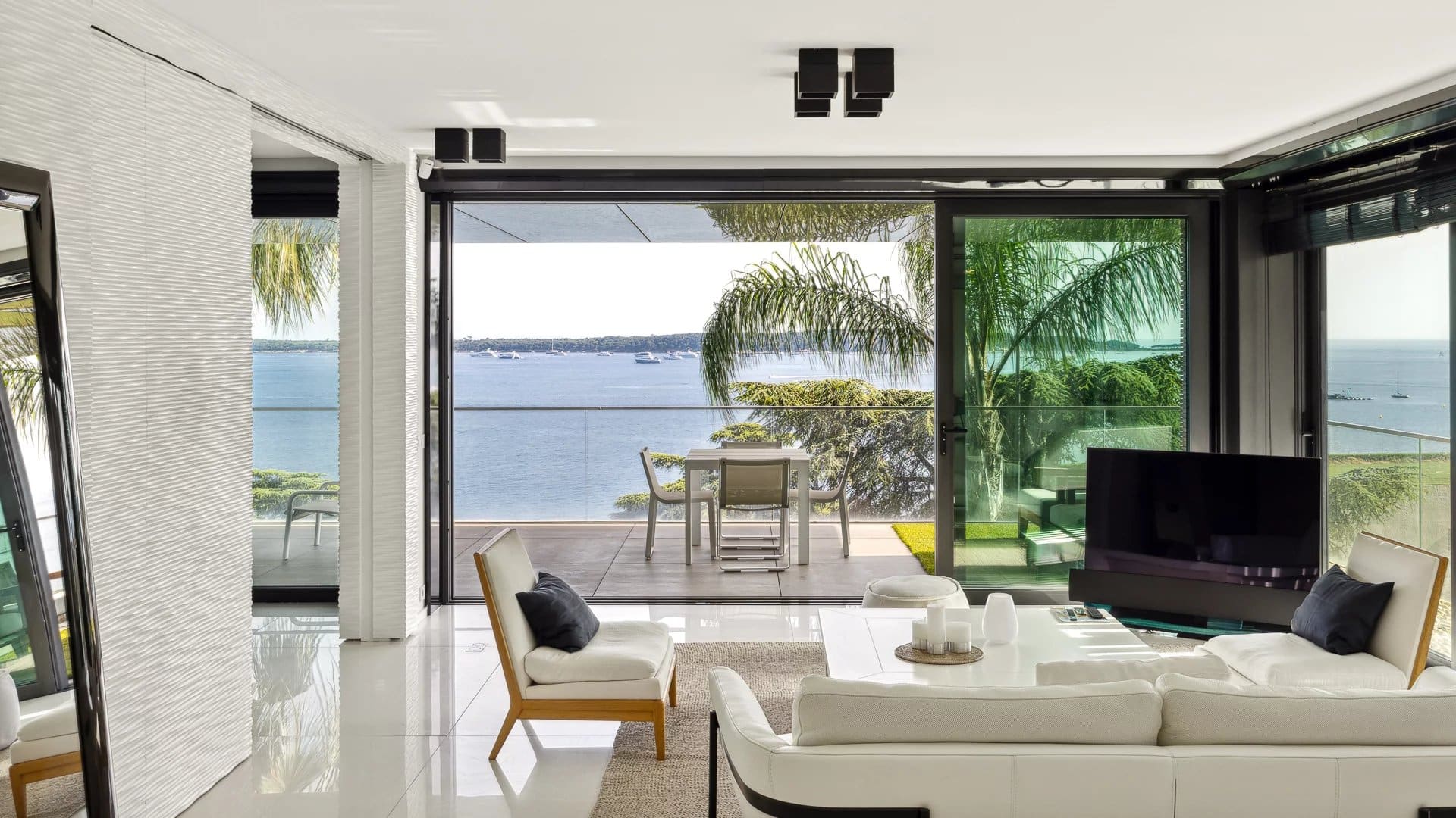 Intérieur d'un appartement de luxe avec vue sur la mer à Cannes, terrasse spacieuse et décoration moderne.