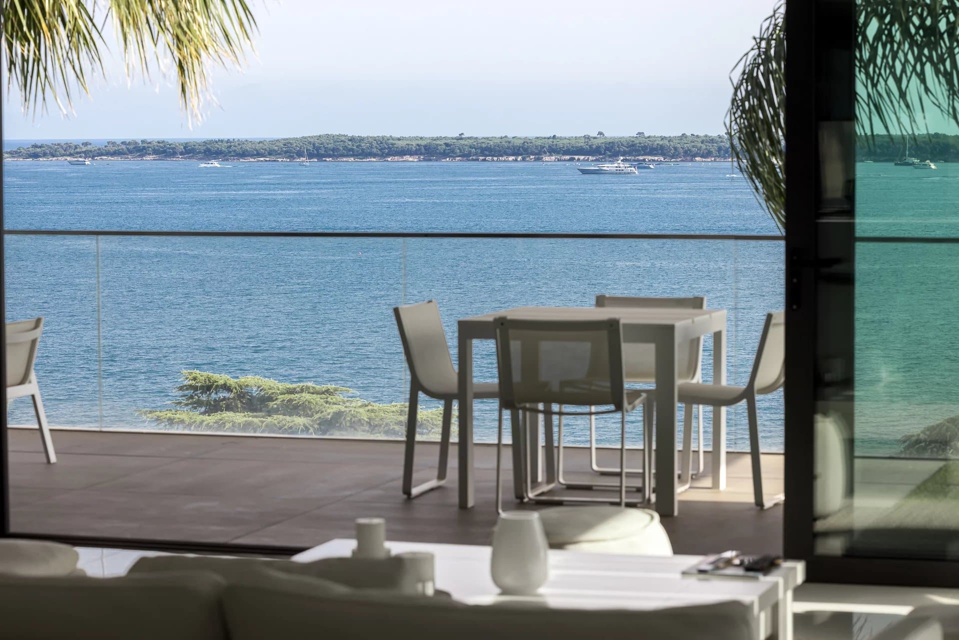 Terrasse d'un appartement à Cannes avec vue sur la mer et mobilier extérieur.
