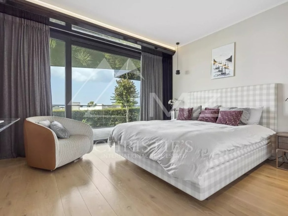 Room in a contemporary apartment with bed, desk and view of the outside in Cannes.