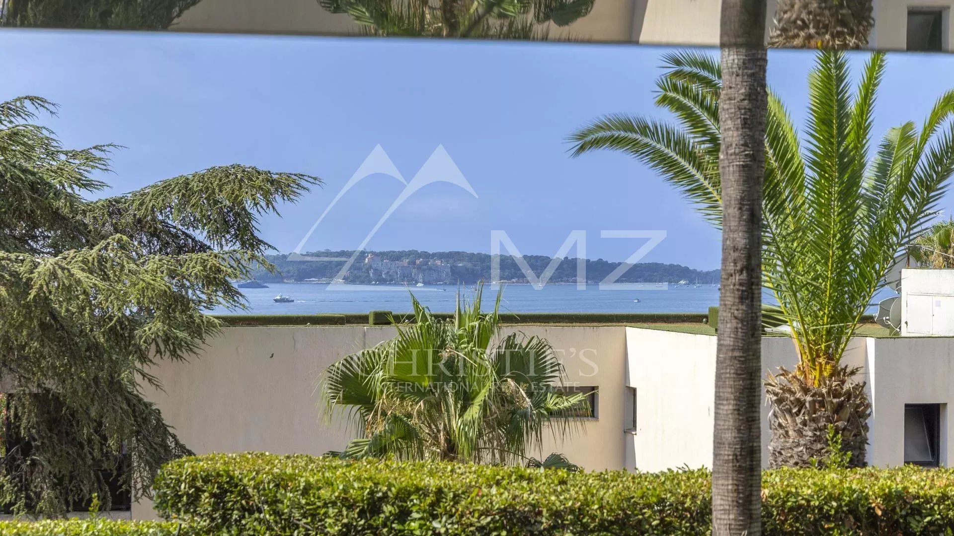 View from a contemporary apartment with palm trees and the sea in the background in Cannes.