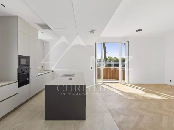 Cuisine moderne d'un appartement rénové à Le Cannet, avec îlot central et grandes fenêtres.