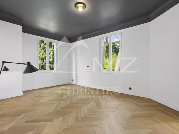 Intérieur d'un appartement rénové avec parquet et fenêtres, situé à Le Cannet.