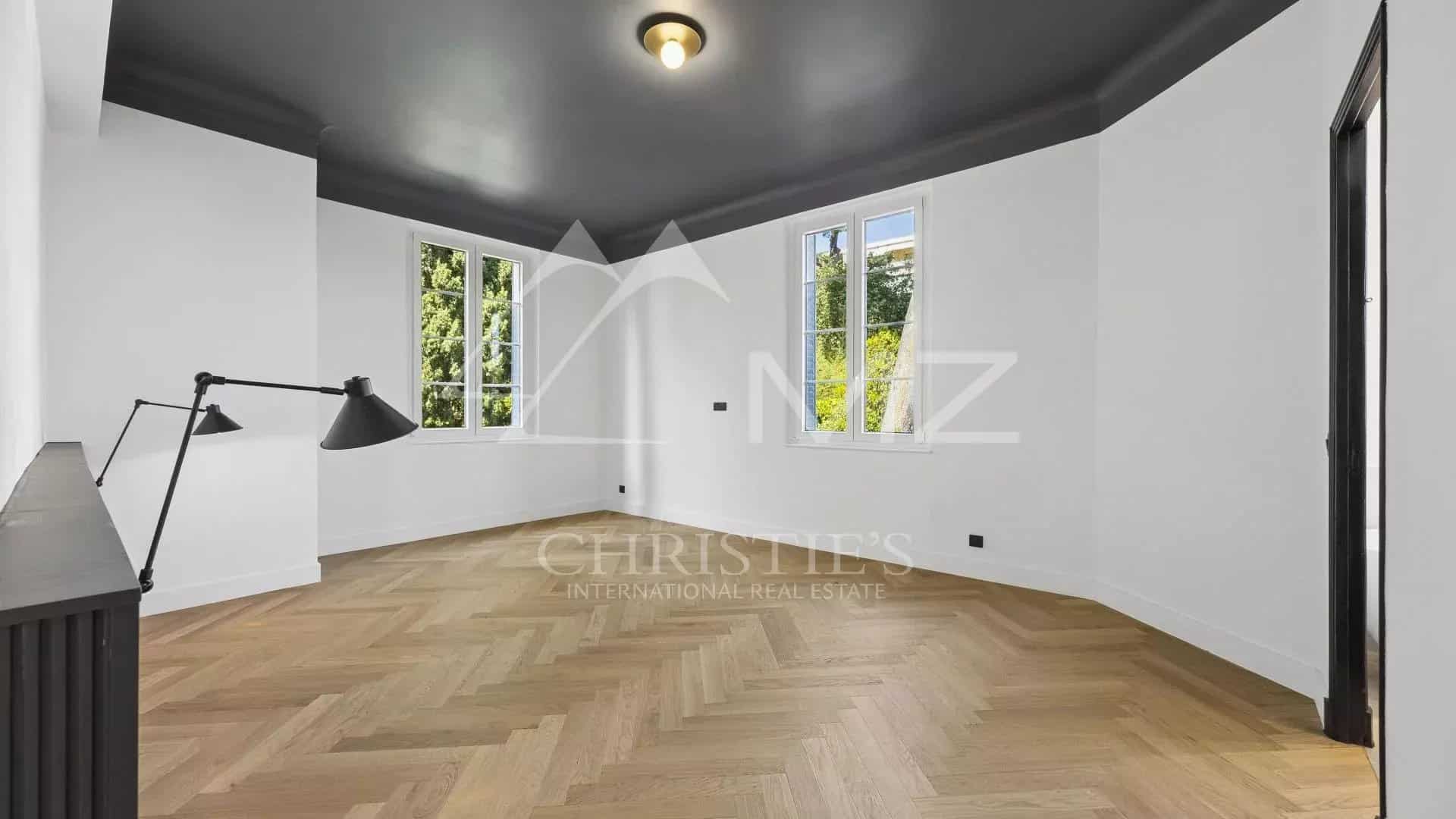 Intérieur d'un appartement rénové avec parquet et fenêtres, situé à Le Cannet.
