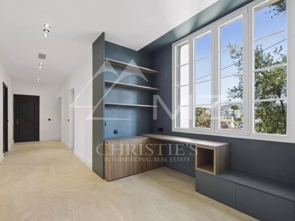Intérieur d'un appartement rénové avec fenêtres et espace de rangement à Le Cannet.
