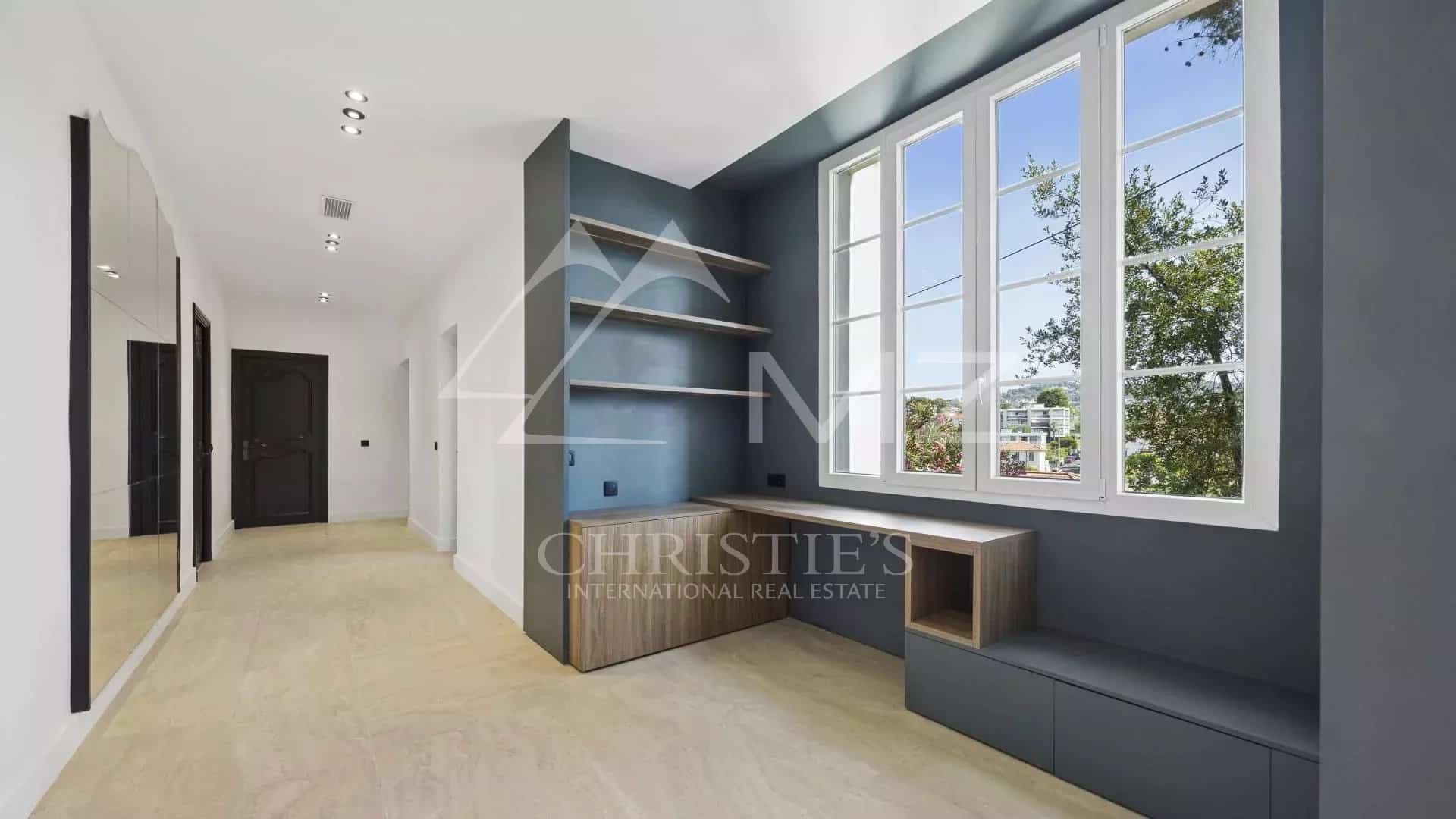 Intérieur d'un appartement rénové avec fenêtres et espace de rangement à Le Cannet.