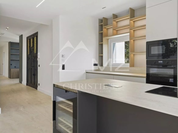 Cuisine moderne d'un appartement rénové à Le Cannet, avec des meubles clairs et un plan de travail en pierre.