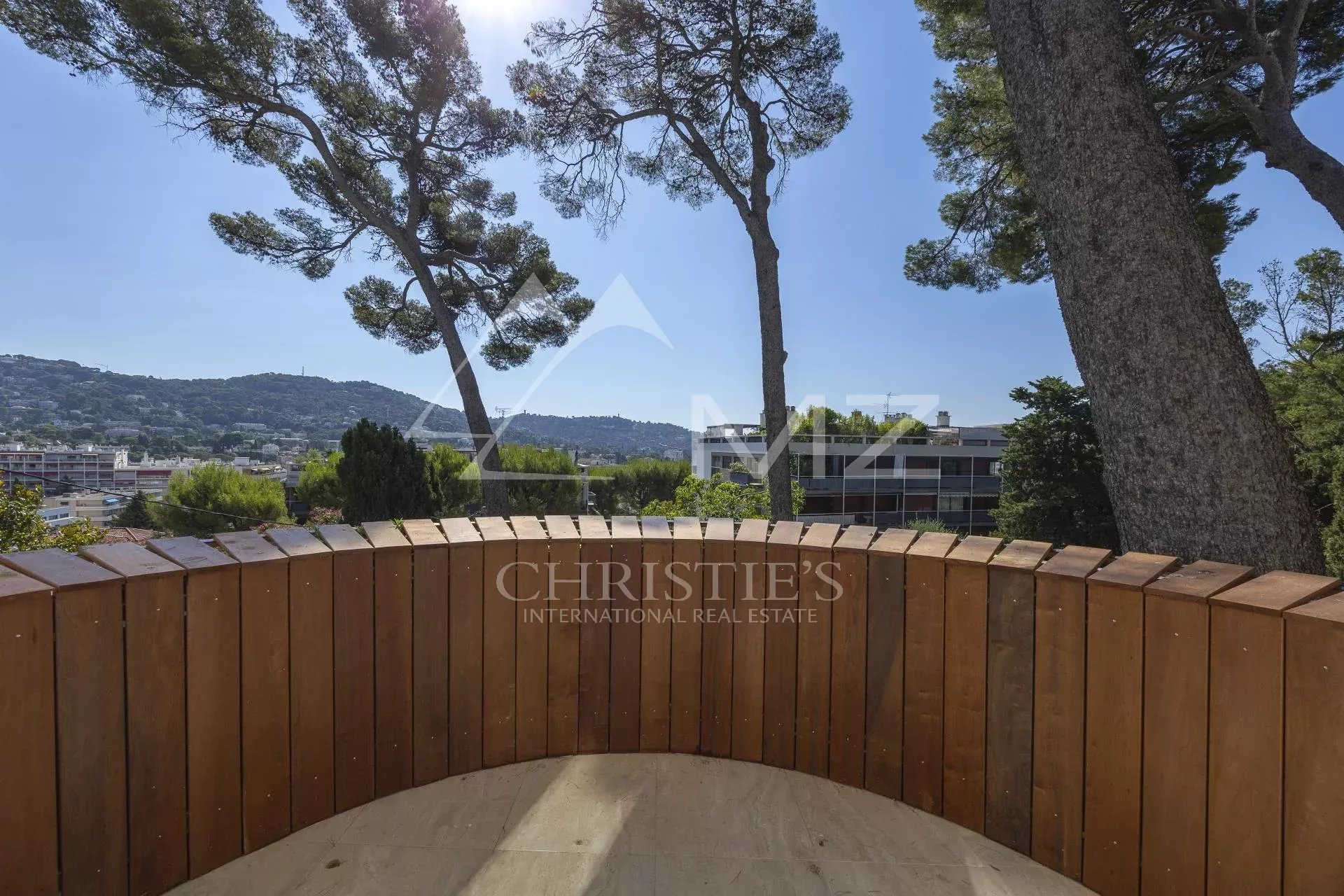 Terrasse en bois avec vue dégagée sur la verdure et les arbres à Le Cannet.