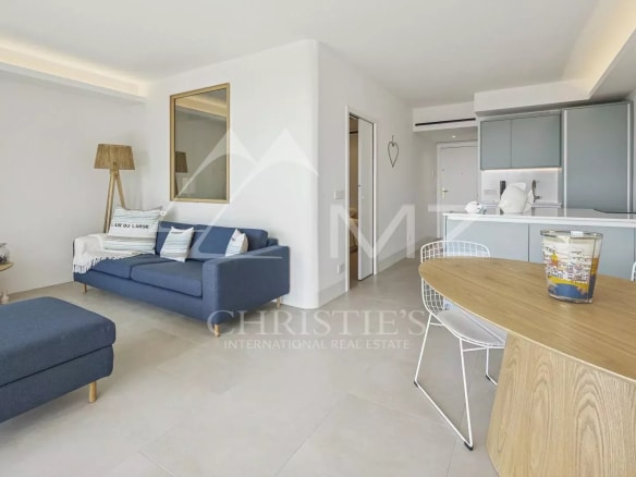 Intérieur d'un appartement rénové avec séjour lumineux et cuisine moderne à Cannes.