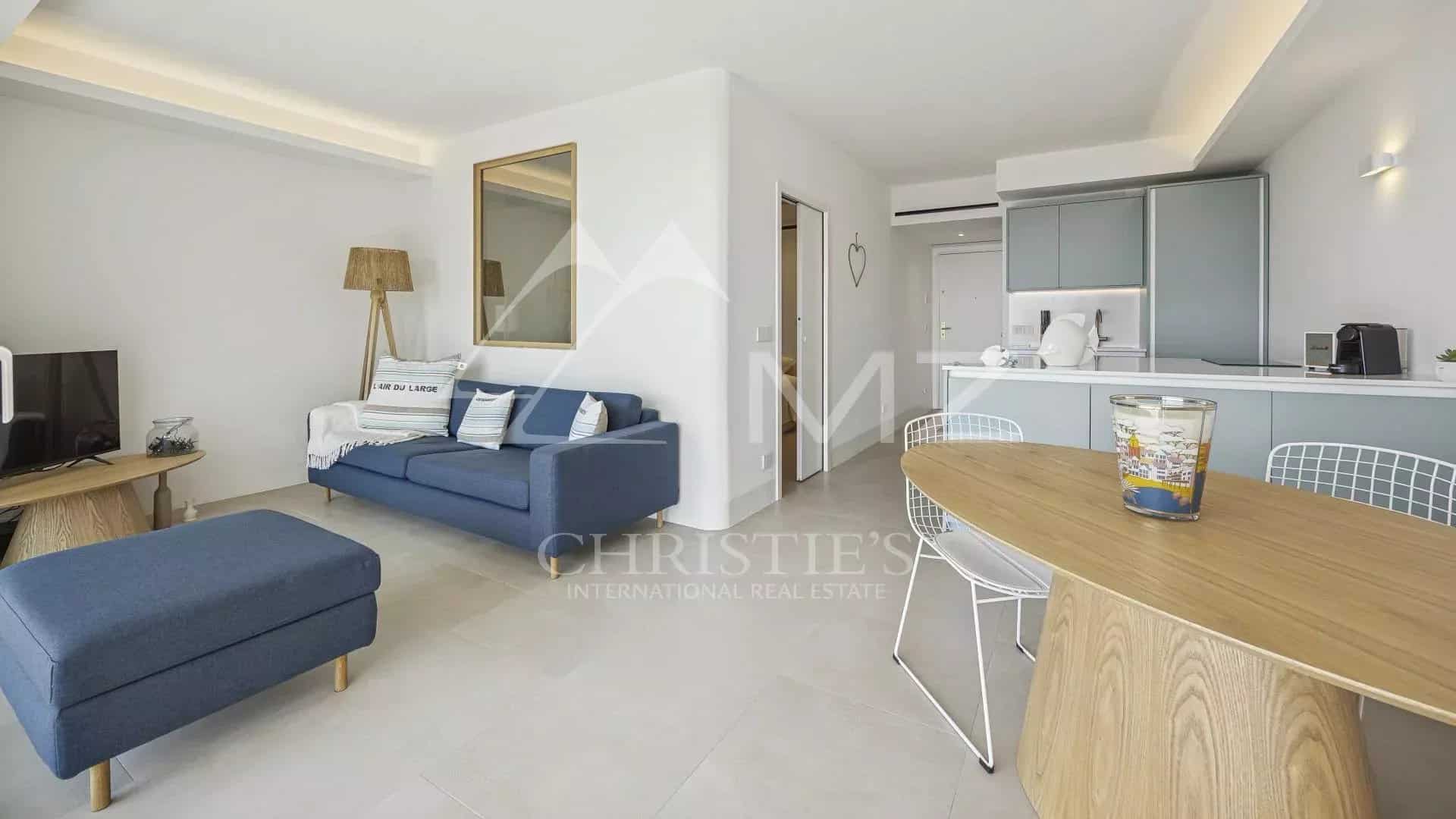 Intérieur d'un appartement rénové avec séjour lumineux et cuisine moderne à Cannes.