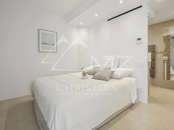 Chambre d'un appartement rénové à Cannes, avec lit double et décoration moderne.