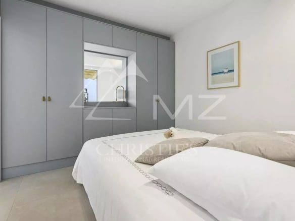 Chambre d'un appartement à Cannes avec lit double et placard intégré.