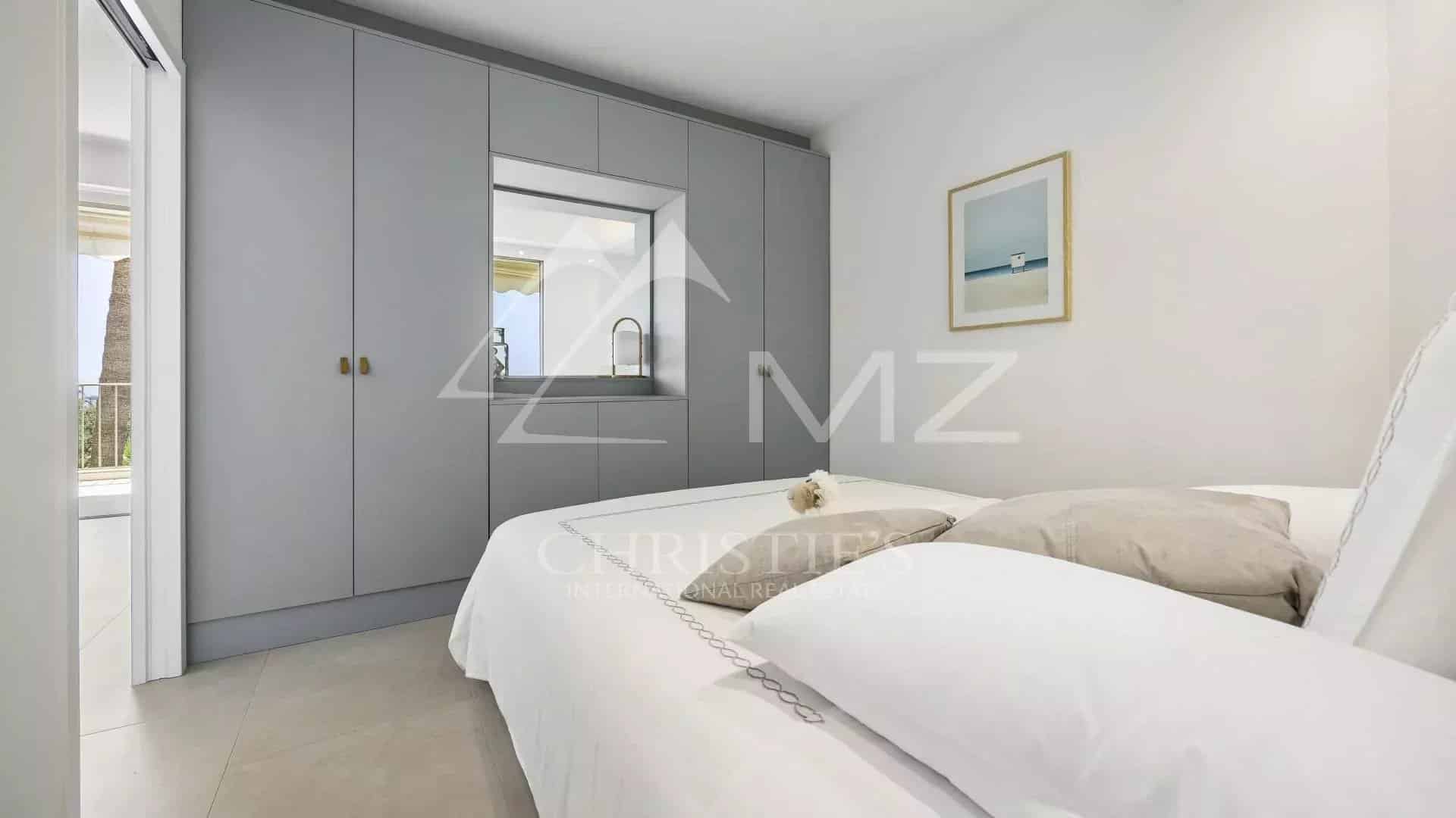 Chambre d'un appartement à Cannes avec lit double et placard intégré.