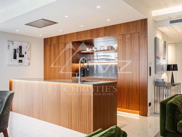 Modern kitchen with a central wooden island and high-end appliances in a penthouse in Cannes.