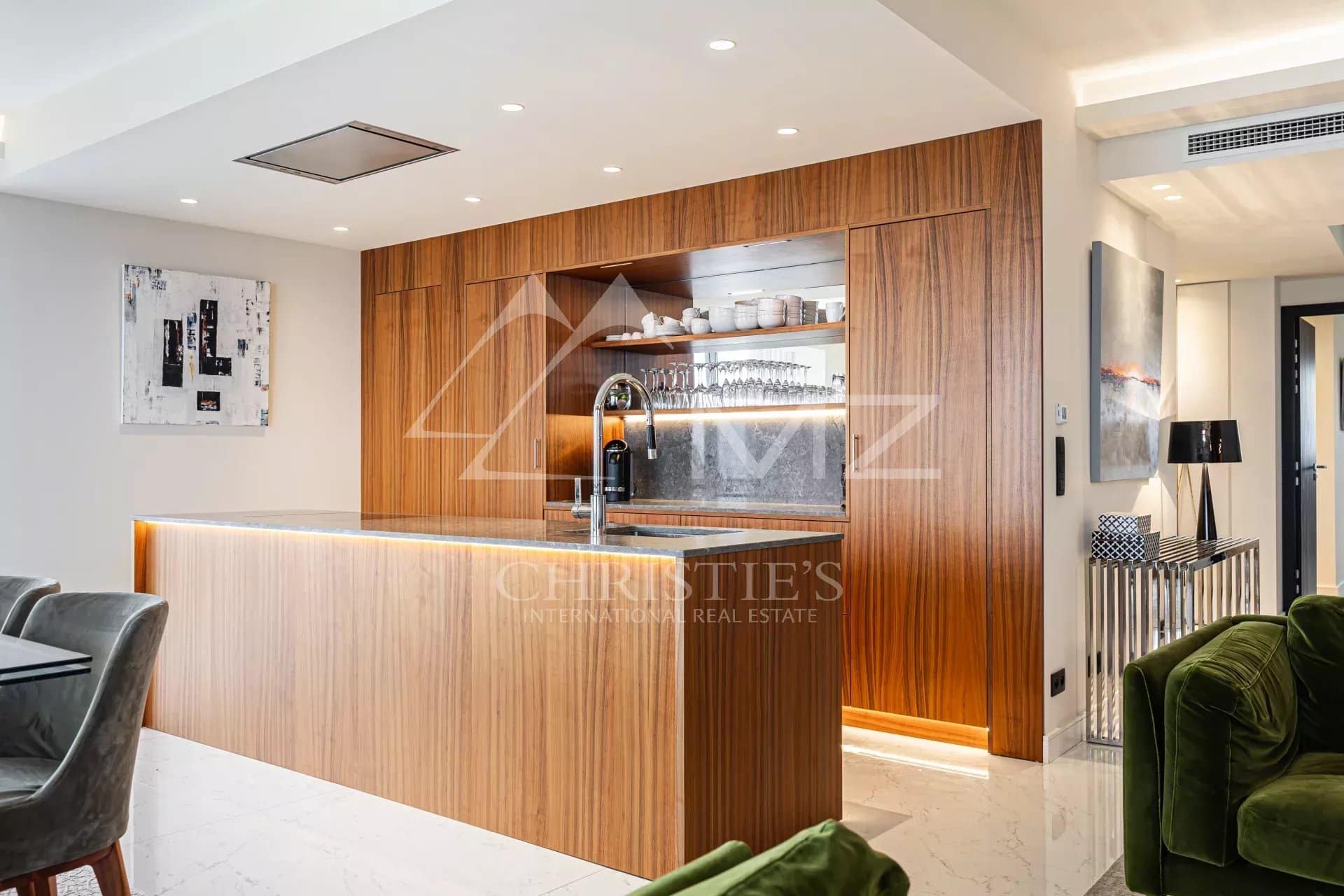 Modern kitchen with a central wooden island and high-end appliances in a penthouse in Cannes.