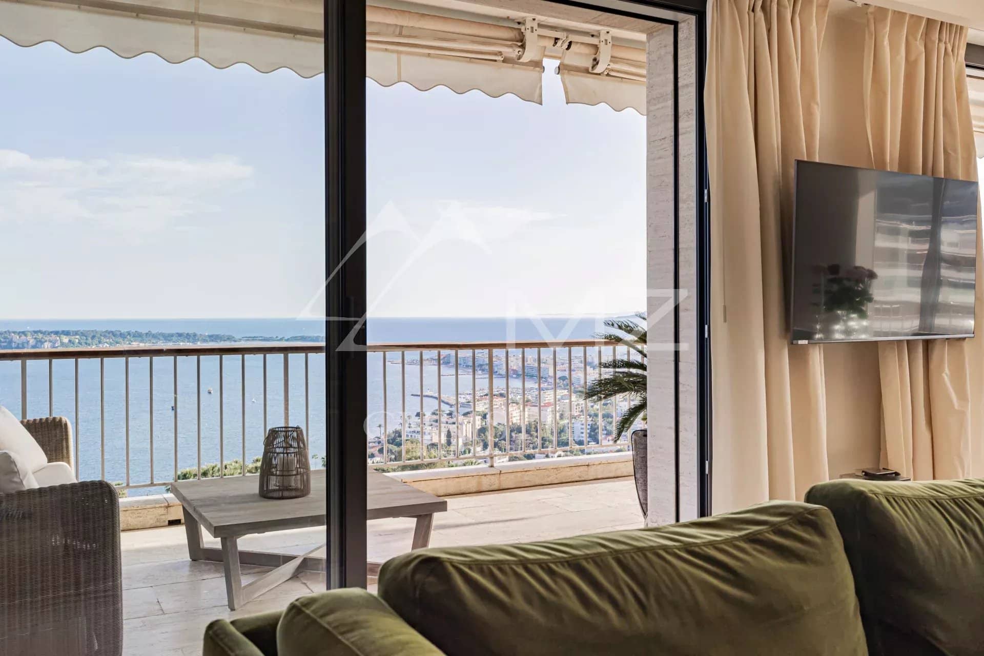 Panoramic sea view from a penthouse in Cannes, with a bright and modern living room.