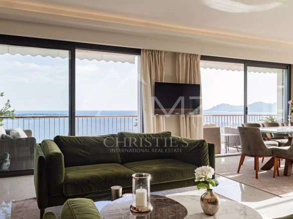 Interior of a penthouse in Cannes with sea view, bright living room and modern furniture.
